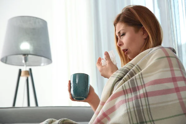 生病的女人在家里裹着格子花和一杯热饮 流感病毒 — 图库照片