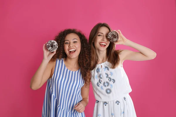 Hermosas Mujeres Jóvenes Con Rosquillas Sobre Fondo Rosa — Foto de Stock