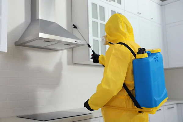 身穿防护服的虫害防治人员在室内家具上喷洒杀虫剂 案文的篇幅 — 图库照片