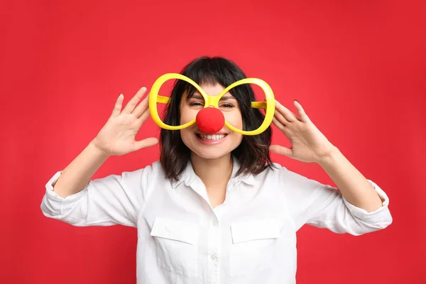 Radosna Kobieta Dużymi Okularami Nosem Klauna Czerwonym Tle Kwietniowy Dzień — Zdjęcie stockowe