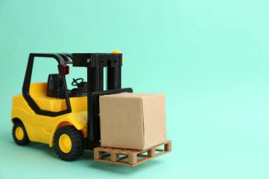 Forklift modeli ve turkuaz arka planda karton kutular, metin için boşluk. Kurye servisi