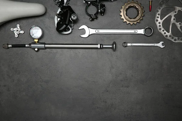 一套不同的自行车工具和零件放在灰色石桌上 案文的篇幅 — 图库照片