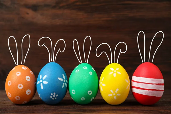 Světlé Velikonoční Vajíčka Roztomilými Králičí Uši Dřevěném Pozadí — Stock fotografie