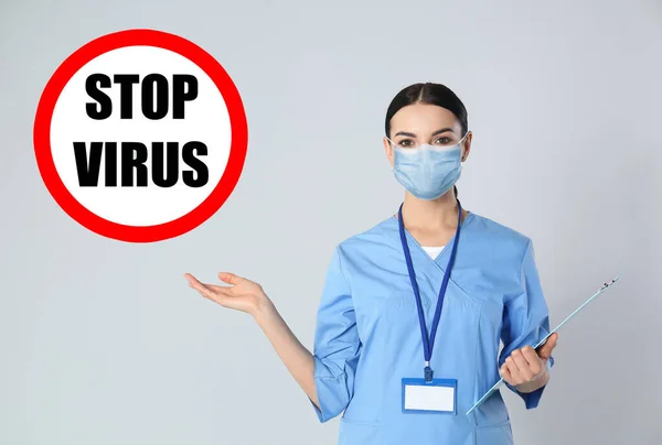 Médico Joven Con Máscara Médica Signo Stop Virus Sobre Fondo — Foto de Stock