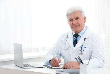 İş yerinde beyaz önlüklü kıdemli doktorun portresi.