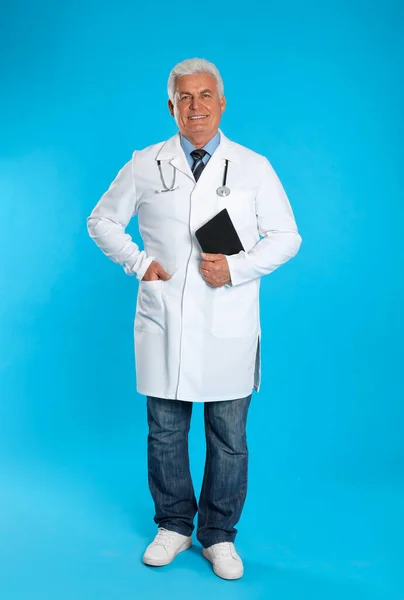 Açık Mavi Arka Planda Panosu Olan Kıdemli Doktor — Stok fotoğraf