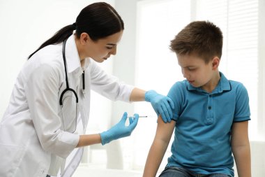 Modern klinikte küçük bir çocuğu aşılayan doktor.