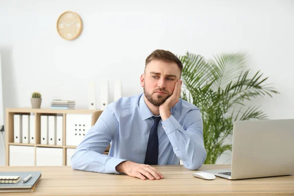 Lazy young office employee procrastinating at workplace