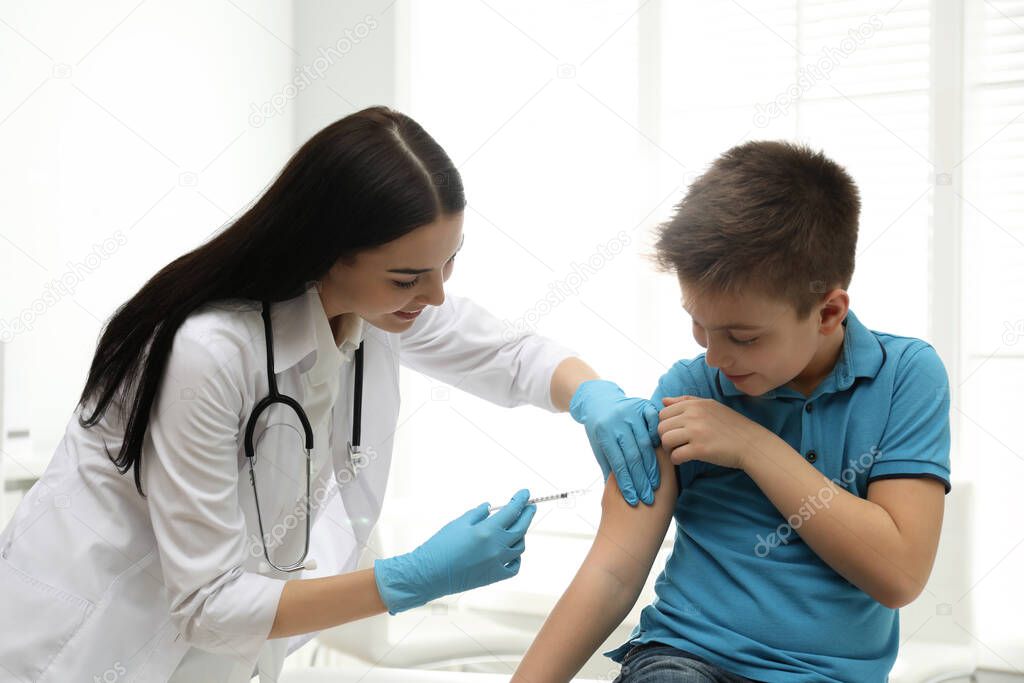 Doctor vaccinating little child in modern clinic