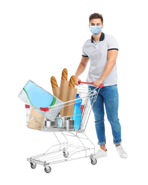 Молодой человек в медицинской маске и корзине с покупками на белом фоне
 