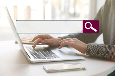 İçerideki masada bilgisayarla çalışan internet tarayıcı ve kadın arama çubuğu.