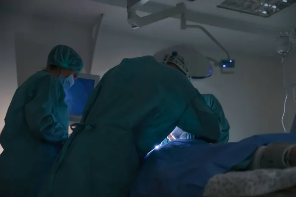 Team of professional doctors performing operation in surgery room