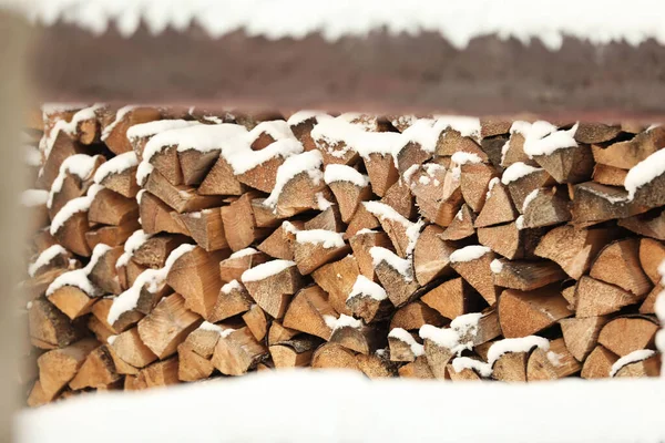屋外で雪に覆われた薪の大きな山 — ストック写真