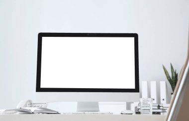 Beyaz duvarın yanındaki boş ekranlı modern bilgisayar. Tasarım için boşluk