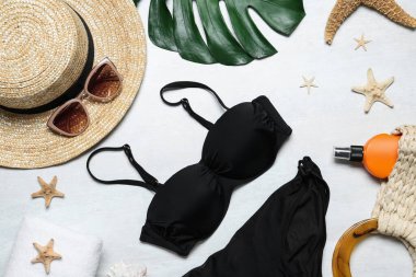 Beyaz arka planda kadın bikinisi olan düz bir kompozisyon.