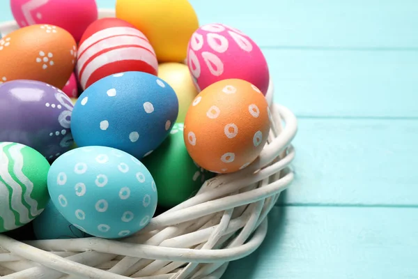 Açık Mavi Ahşap Arka Planda Dekoratif Yuvada Renkli Paskalya Yumurtaları — Stok fotoğraf