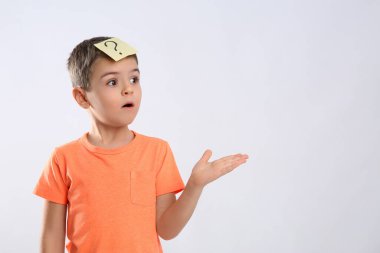 Beyaz arka planda soru işareti olan duygusal küçük çocuk.