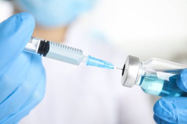 Şırıngayı ilaçla dolduran doktor, yakın çekim. Aşılama ve aşılama