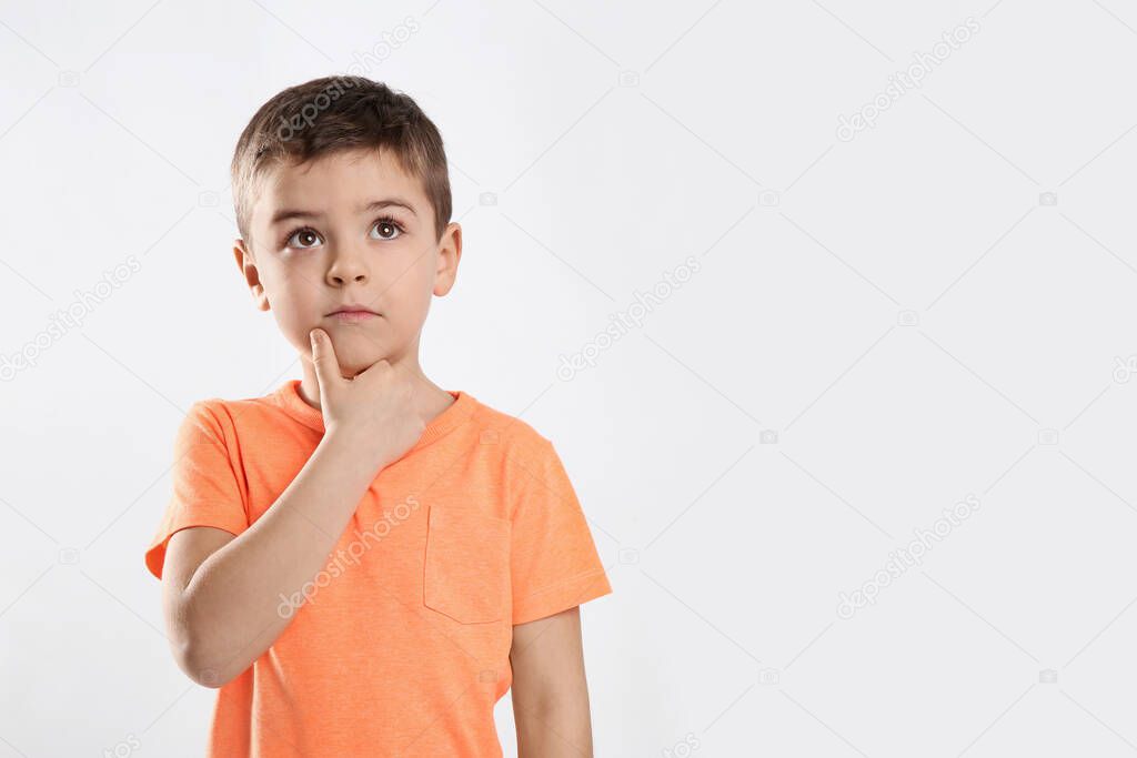 Emotional little boy in casual outfit on white background