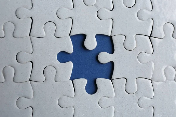 White puzzle with missing piece on blue background, top view. Career promotion concept