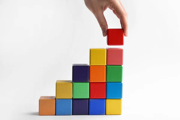 Mulher Construindo Escadas Com Cubos Coloridos Fundo Branco Close Conceito — Fotografia de Stock