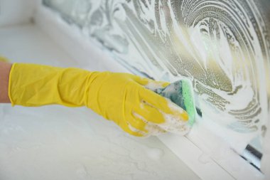 Pencereyi süngerle temizleyen kadın, yakın görünüm