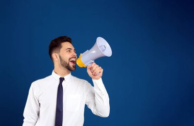 Mavi arka planda megafonu olan genç adam.