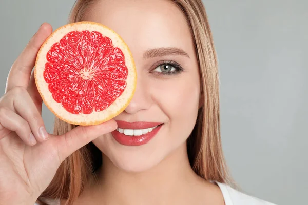 Jonge Vrouw Met Gesneden Grapefruit Grijze Achtergrond Vitaminerijk Voedsel — Stockfoto