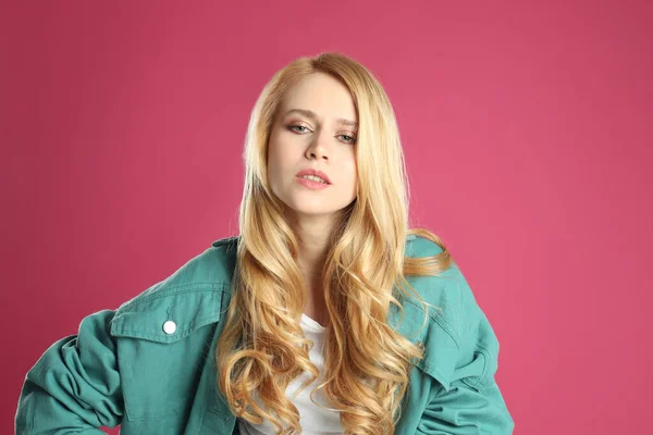 ピンクの背景に長い髪を染めて美しい若い女性の肖像画 — ストック写真