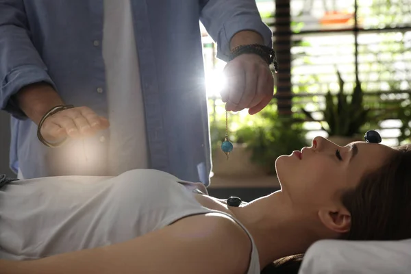 Young woman during crystal healing session in therapy room