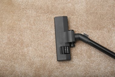 Modern elektrikli süpürgeyle halıdaki toprağı kaldırmak, üst manzara. Metin için boşluk