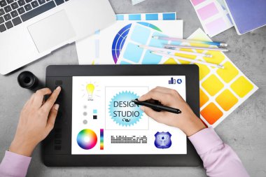 Gri Taş Masa 'da grafik tabletle çalışan profesyonel kadın tasarımcının üst görüntüsü, yakın plan. 