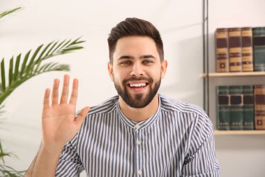 Evde görüntülü konuşma yapan genç adam, web kamerasından görüntü
