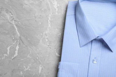 Gri mermer masada açık mavi gömlekli, üst manzaralı, yazı için yeri olan. Kuru temizleme servisi.