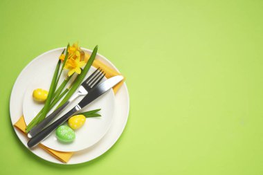 Güzel narsisleri ve boyalı yumurtaları olan Paskalya sofrası, üst manzara. Metin için boşluk
