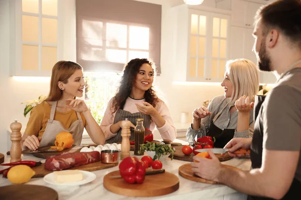 Happy people cooking food together in kitchen