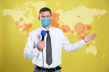 Coronavirus salgını sırasında tıbbi maskeli bir gazeteci haber sunuyor. Hastalığın yayıldığını gösteren dünya haritası
