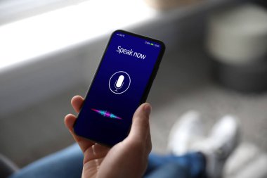 İçerideki akıllı telefondan ses araması yapan adam, yakın plan.