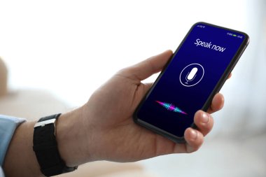 İçerideki akıllı telefondan ses araması yapan adam, yakın plan.