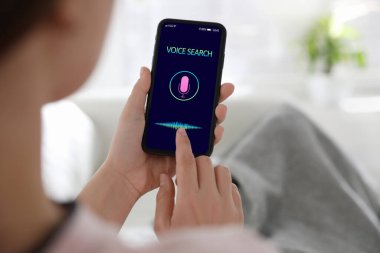 İçerideki akıllı telefondan ses araması yapan kadın, yakın plan.
