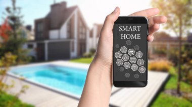 Açık havada akıllı evleri kontrol etmek için telefon uygulaması kullanan bir kadın.