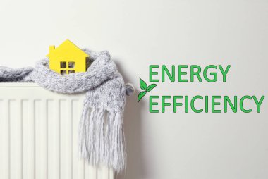 Enerji verimliliği kavramı. Radyatöre sarılı ev modeli.