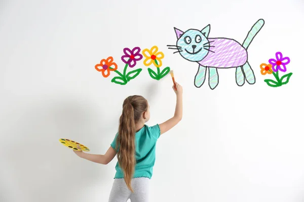Niedliches Kind Zeichnet Katze Und Blumen Weiße Wand Drinnen — Stockfoto