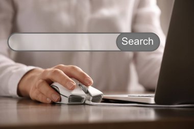 Masada dizüstü bilgisayarı olan bilgisayar faresi kullanan internet tarayıcı ve kadın arama çubuğu, yakın plan