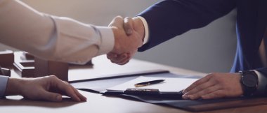 Erkek avukat ofiste müvekkil ile tokalaşıyor, yakın plan. Pankart tasarımı