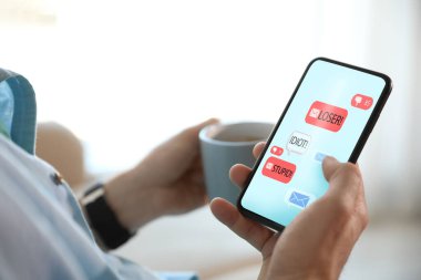 Akıllı telefonu içeride tutan adam, yakın plan. Siber zorbalık kavramı 
