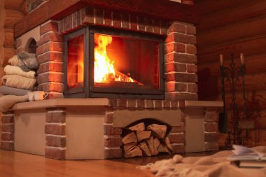 Fireplace with burning wood in room. Winter vacation clipart