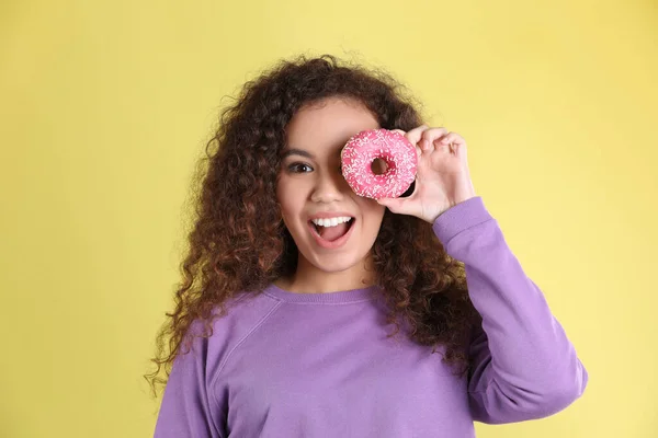 Sarı Arka Planda Donutu Olan Güzel Bir Afro Amerikalı Kadın — Stok fotoğraf