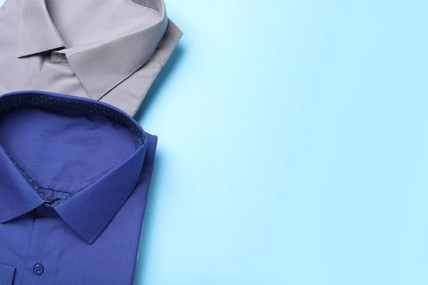 浅蓝色背景的时髦衬衫 平平平的躺着 上面有文字的空间 干洗服务 — 图库照片
