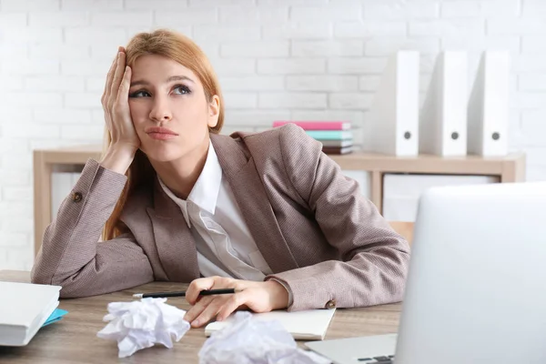 Lazy employee wasting time at table in office